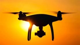 Un drone munie d’une caméra vole dans le ciel couchant